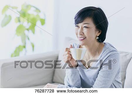 Stock Photo - Japanese senior woman on sofa. Fotosearch