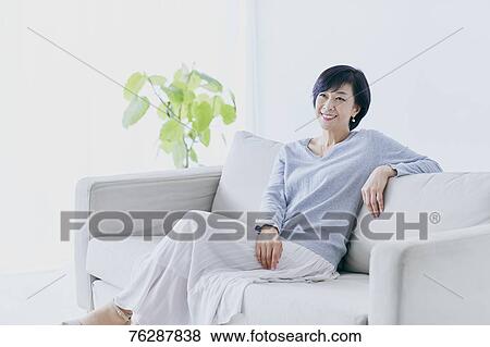 Stock Photo - Japanese senior woman on sofa. Fotosearch