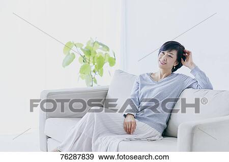 Stock Photo - Japanese senior woman on sofa. Fotosearch