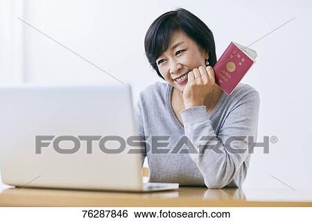 Stock Photograph - Japanese senior woman planning trip. Fotosearch