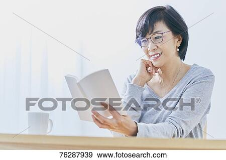 Japanese senior woman reading book at table View Large Photo Image Stock Photo - Japanese senior woman reading book at table. Fotosearch