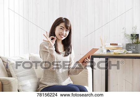Picture - Japanese woman buying online. Fotosearch