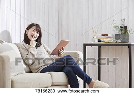 Stock Image - Japanese woman buying online. Fotosearch