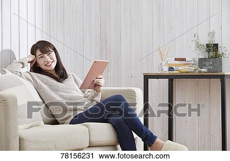 Stock Image - Japanese woman buying online. Fotosearch