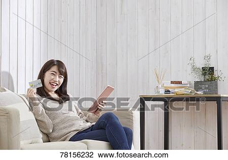 Stock Image - Japanese woman buying online. Fotosearch