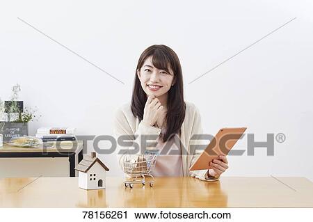 Stock Image - Japanese woman buying online. Fotosearch