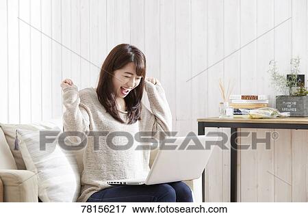 Stock Photo - Japanese woman buying online. Fotosearch