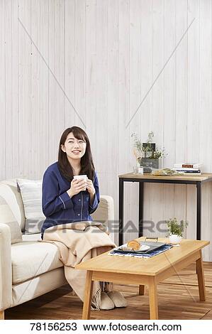 Stock Image - Japanese woman eating in a pajamas. Fotosearch