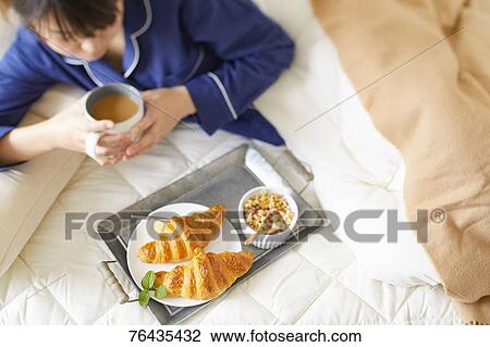 Japanese woman having breakfast in bed View Large Photo Image Stock Image - Japanese woman having breakfast in bed. Fotosearch
