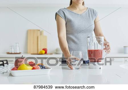 Japanese woman making smoothie in the kitchen View Large Photo Image Stock Photo - Japanese woman making smoothie in the kitchen. Fotosearch