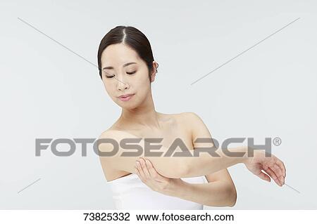 Stock Image - Japanese woman massaging. Fotosearch