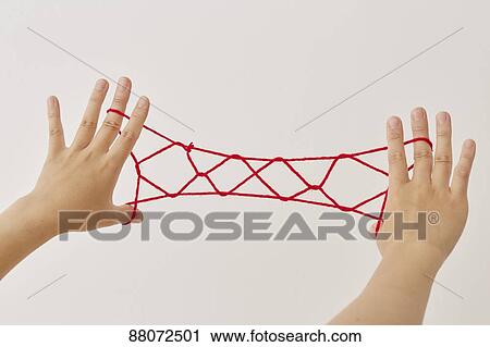 Stock Image - Japanese woman playing with red string. Fotosearch