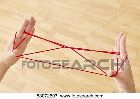 Stock Photo - Japanese woman playing with red string. Fotosearch