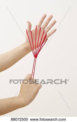 Stock Photography - Japanese woman playing with red string. Fotosearch