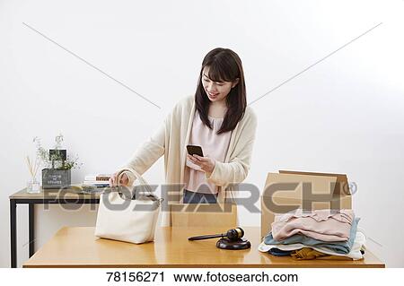 Stock Image - Japanese woman selling online. Fotosearch