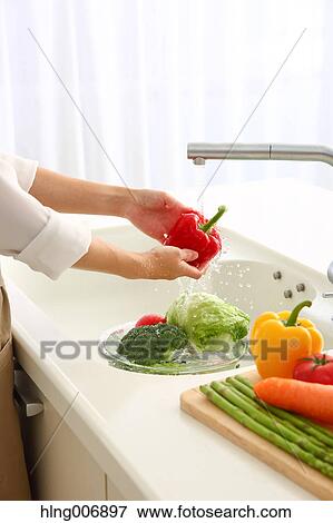 Japanese woman washing vegetables in the kitchen View Large Photo Image Stock Photo - Japanese woman washing vegetables in the kitchen. Fotosearch