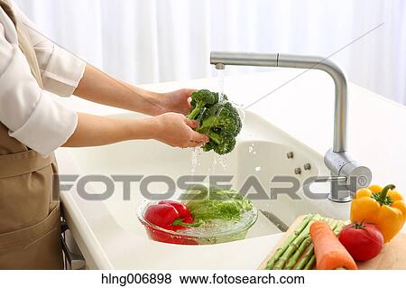 Japanese woman washing vegetables in the kitchen View Large Photo Image Stock Photo - Japanese woman washing vegetables in the kitchen. Fotosearch