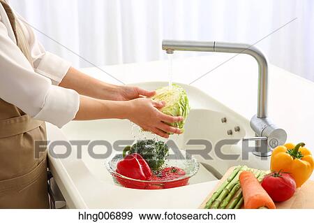 Japanese woman washing vegetables in the kitchen View Large Photo Image Stock Photo - Japanese woman washing vegetables in the kitchen. Fotosearch