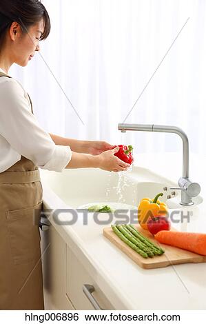Japanese woman washing vegetables in the kitchen View Large Photo Image Stock Photograph - Japanese woman washing vegetables in the kitchen. Fotosearch