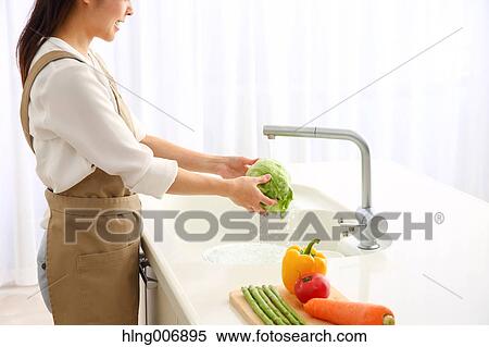 Japanese woman washing vegetables in the kitchen View Large Photo Image Stock Photography - Japanese woman washing vegetables in the kitchen. Fotosearch