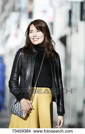 Picture - Japanese woman window shopping downtown Tokyo. Fotosearch