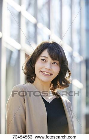 Stock Image - Japanese woman window shopping downtown Tokyo. Fotosearch
