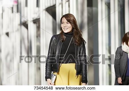 Stock Photo - Japanese woman window shopping downtown Tokyo. Fotosearch