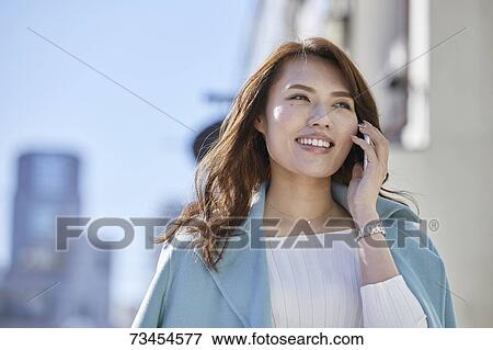 Stock Photo - Japanese woman window shopping downtown Tokyo. Fotosearch