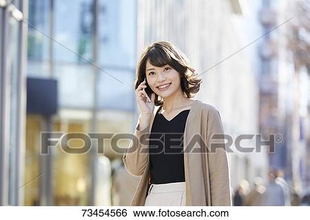 Stock Photograph - Japanese woman window shopping downtown Tokyo. Fotosearch