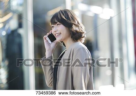 Stock Photograph - Japanese woman window shopping downtown Tokyo. Fotosearch