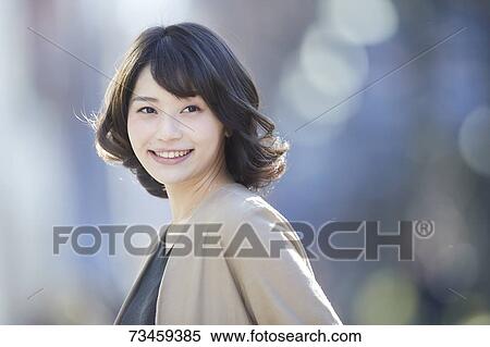 Stock Photography - Japanese woman window shopping downtown Tokyo. Fotosearch