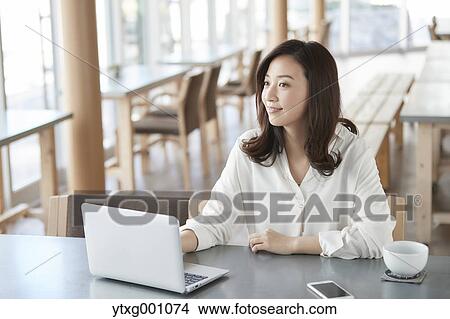 Japanese woman with laptop in a stylish cafe View Large Photo Image Picture - Japanese woman with laptop in a stylish cafe. Fotosearch
