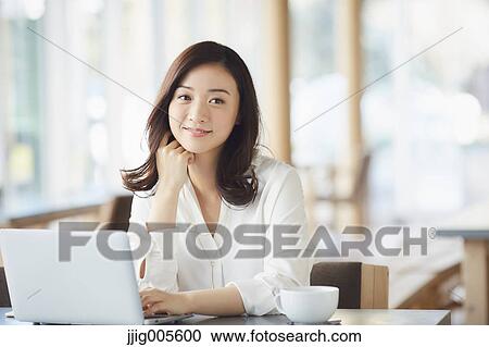 Japanese woman with laptop in a stylish cafe View Large Photo Image Stock Image - Japanese woman with laptop in a stylish cafe. Fotosearch