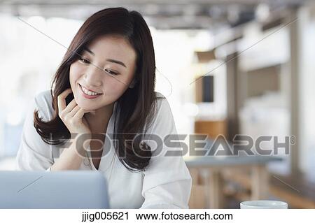 Japanese woman with laptop in a stylish cafe View Large Photo Image Stock Image - Japanese woman with laptop in a stylish cafe. Fotosearch