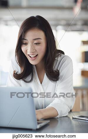 Japanese woman with laptop in a stylish cafe View Large Photo Image Stock Image - Japanese woman with laptop in a stylish cafe. Fotosearch