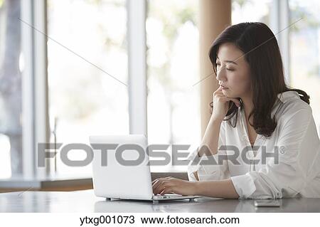 Japanese woman with laptop in a stylish cafe View Large Photo Image Stock Image - Japanese woman with laptop in a stylish cafe. Fotosearch