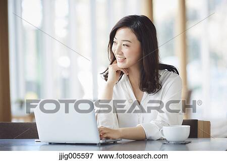 Japanese woman with laptop in a stylish cafe View Large Photo Image Stock Photo - Japanese woman with laptop in a stylish cafe. Fotosearch