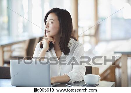 Japanese woman with laptop in a stylish cafe View Large Photo Image Stock Photo - Japanese woman with laptop in a stylish cafe. Fotosearch