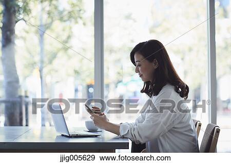 Japanese woman with laptop in a stylish cafe View Large Photo Image Stock Photo - Japanese woman with laptop in a stylish cafe. Fotosearch