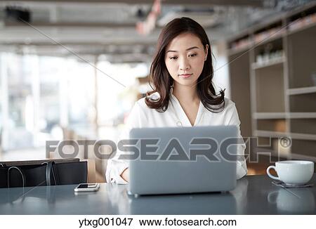 Japanese woman with laptop in a stylish cafe View Large Photo Image Stock Photo - Japanese woman with laptop in a stylish cafe. Fotosearch