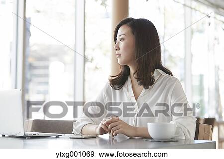 Japanese woman with laptop in a stylish cafe View Large Photo Image Stock Photo - Japanese woman with laptop in a stylish cafe. Fotosearch