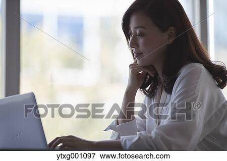 Japanese woman with laptop in a stylish cafe View Large Photo Image Stock Photo - Japanese woman with laptop in a stylish cafe. Fotosearch