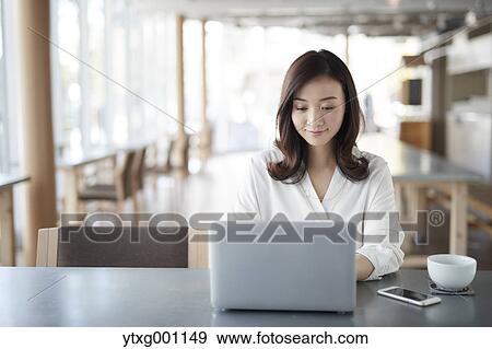 Japanese woman with laptop in a stylish cafe View Large Photo Image Stock Photo - Japanese woman with laptop in a stylish cafe. Fotosearch