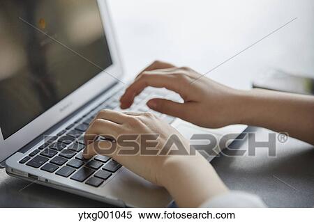 Stock Photography - Japanese woman with laptop in a stylish cafe. Fotosearch