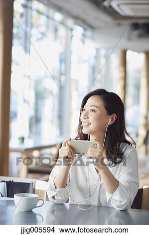 Japanese woman with smartphone in a stylish cafe View Large Photo Image Picture - Japanese woman with smartphone in a stylish cafe. Fotosearch