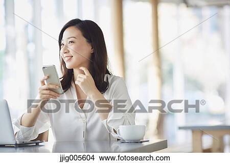 Japanese woman with smartphone in a stylish cafe View Large Photo Image Picture - Japanese woman with smartphone in a stylish cafe. Fotosearch