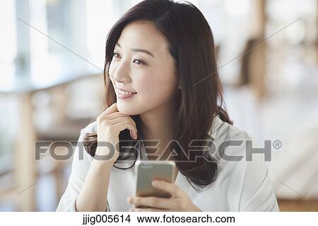 Japanese woman with smartphone in a stylish cafe View Large Photo Image Picture - Japanese woman with smartphone in a stylish cafe. Fotosearch