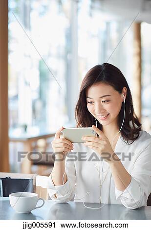 Japanese woman with smartphone in a stylish cafe View Large Photo Image Stock Image - Japanese woman with smartphone in a stylish cafe. Fotosearch