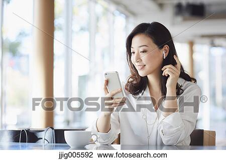Japanese woman with smartphone in a stylish cafe View Large Photo Image Stock Image - Japanese woman with smartphone in a stylish cafe. Fotosearch