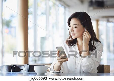 Japanese woman with smartphone in a stylish cafe View Large Photo Image Stock Image - Japanese woman with smartphone in a stylish cafe. Fotosearch